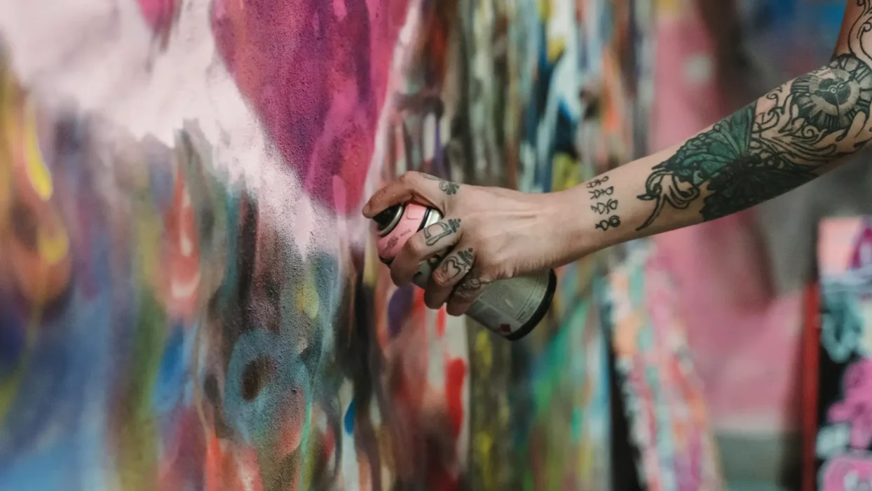 A Person with Tattoos Using a Spray Can